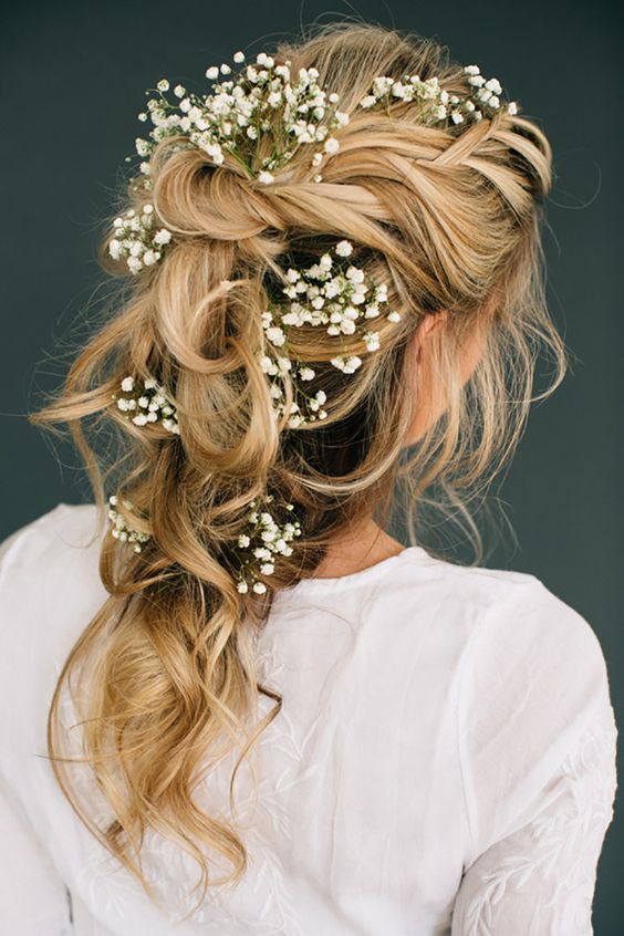 a textural half updo with a side fishtail braid and a greenery and succulent crown for a boho bride