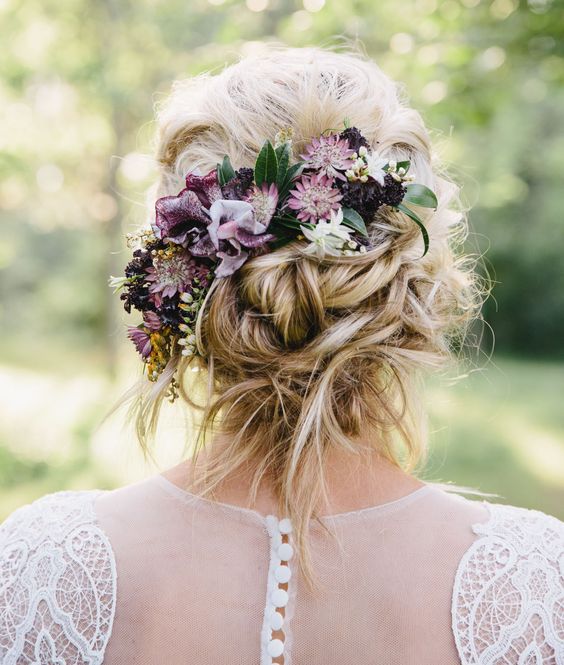 a messy twisted and braided updo with a braided halo and some curls down for a boho bride