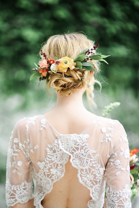 a textural messy updo with braids, a bump and little flowers to add a touch of color