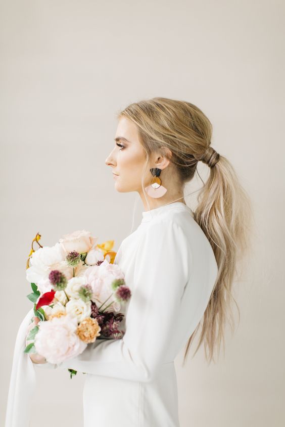 a loose wavy ponytail with some locks down is perfect as a casual wedding hairstyle