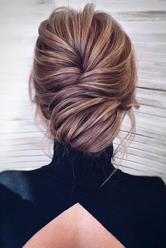 a French twist low updo with a messy look and texture for an elegant yet effortless look