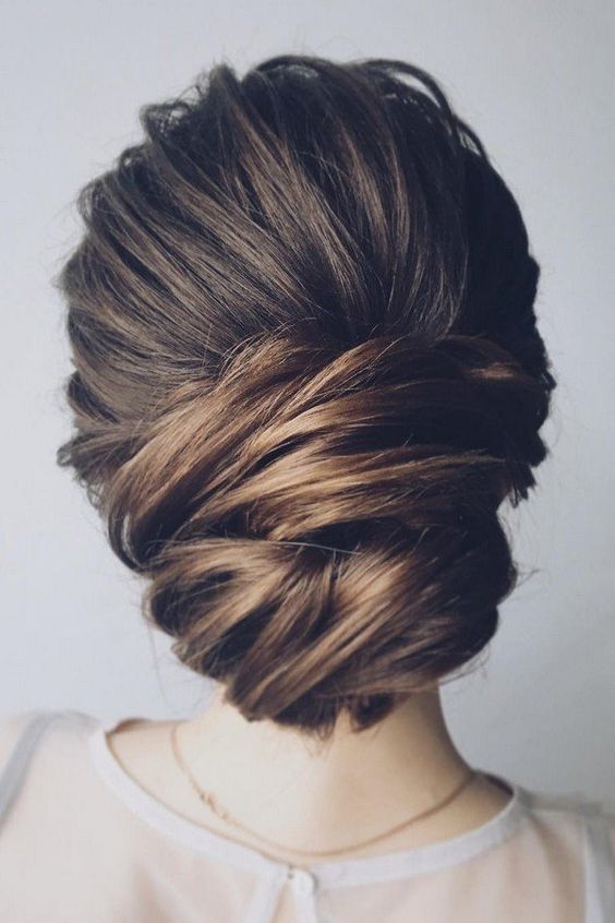 a elegant low chignon with a sideswept section is a very durable option for a picture-perfect look