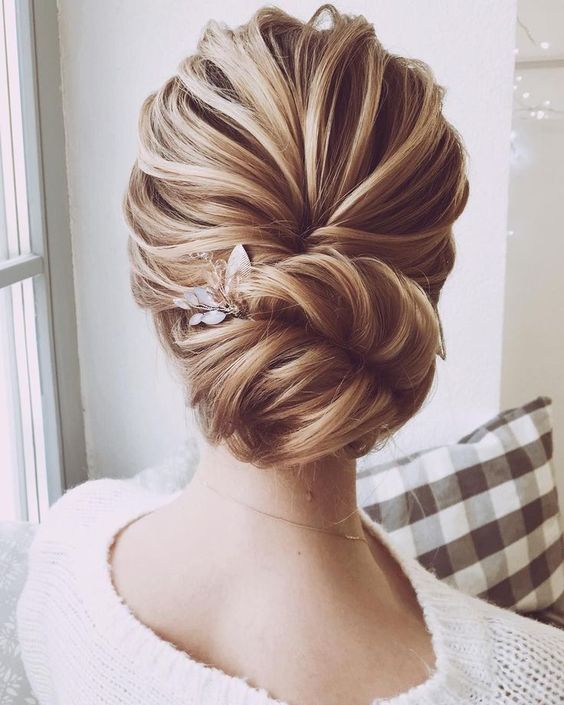a simple yet timelessly elegant low bun hairstyle with some bangs is all you need for a chic look