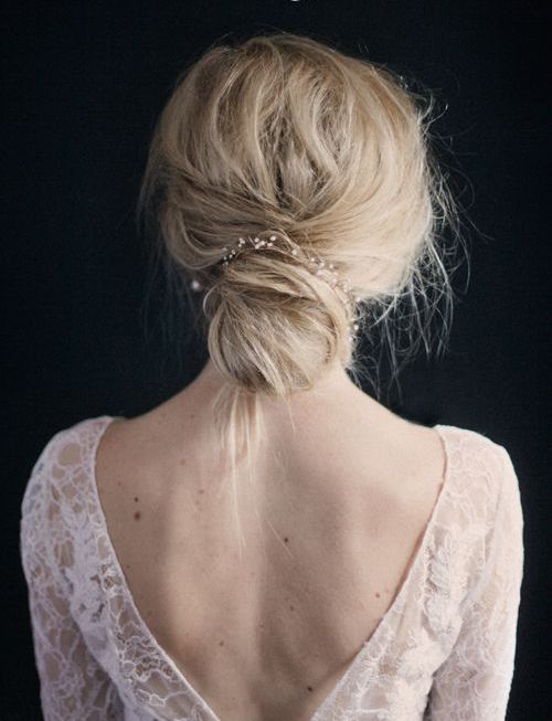 a messy chignon hairstyle with bangs and a rhinestone hairpiece for a modern casual bride