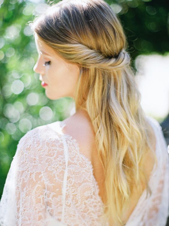 a braided and twisted low bun integrating several braids at once and accessorized with a vintage hairpiece with rhinestones