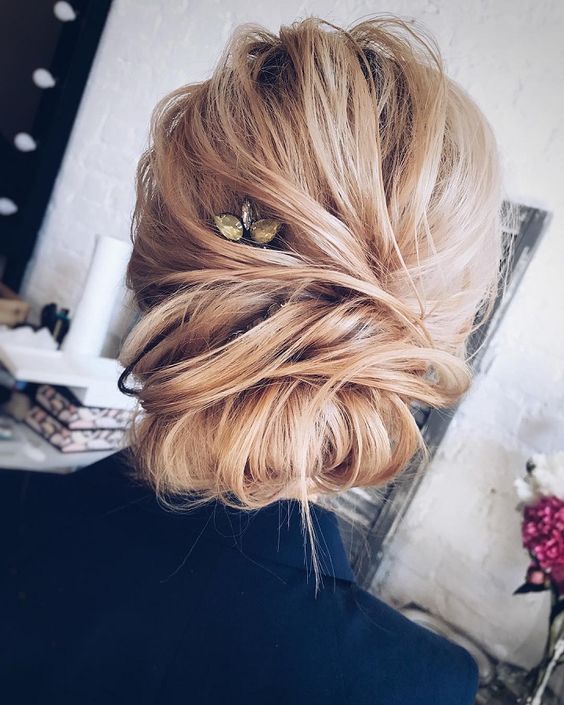 a casual messy updo with a twisted chignon and a rhinestone hairpiece to accentuate it