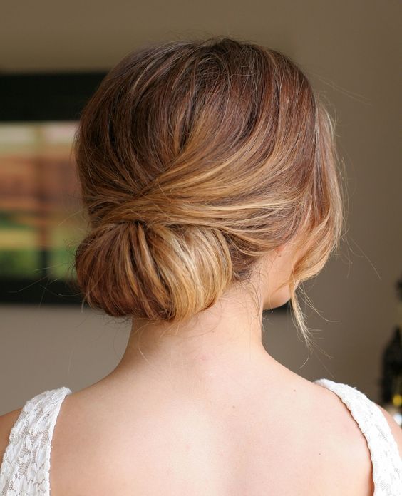 a very messy low updo with twists and bangs for an effortlessly chic look