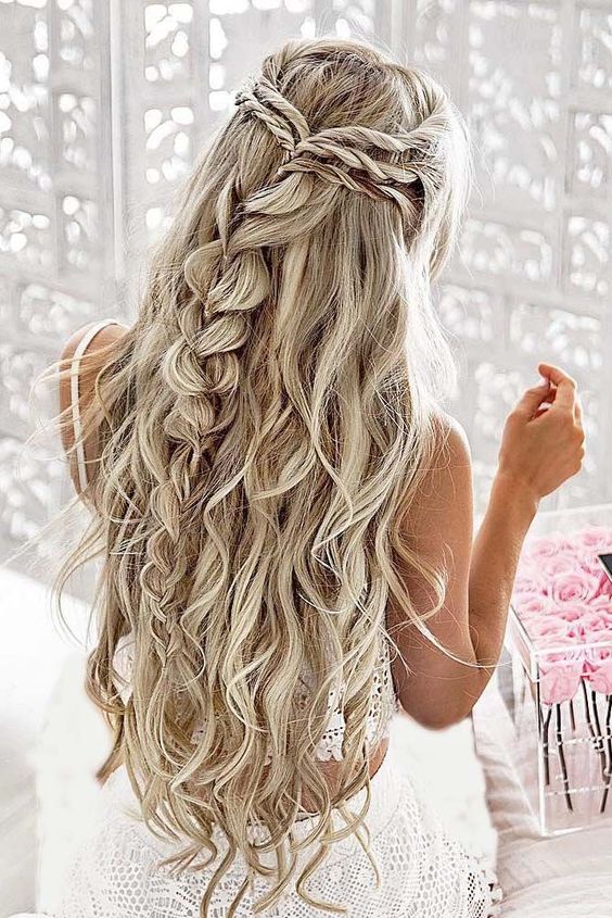 a twisted and braided half updo with messy beachy waves for a boho or free-spirited bride