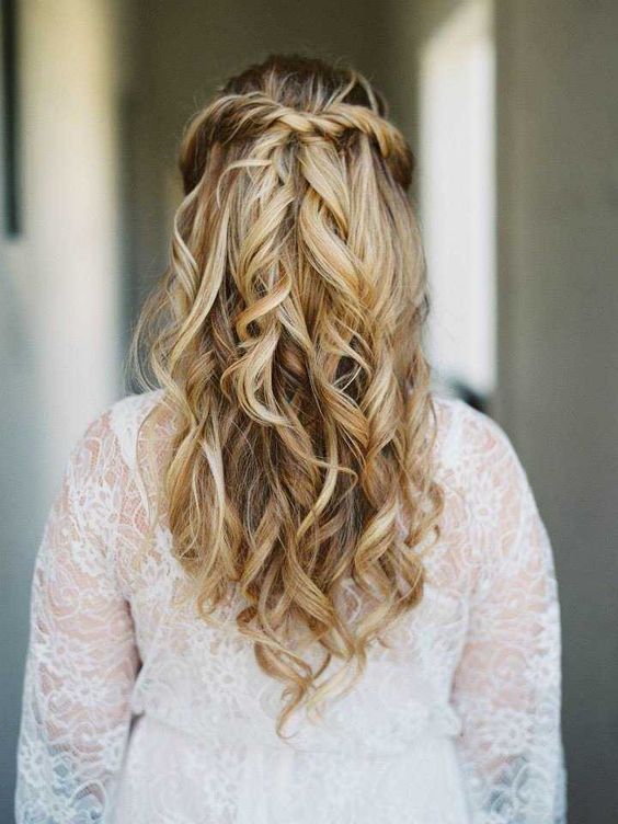 a romantic twisted wavy half updo with a beautiful hair vine