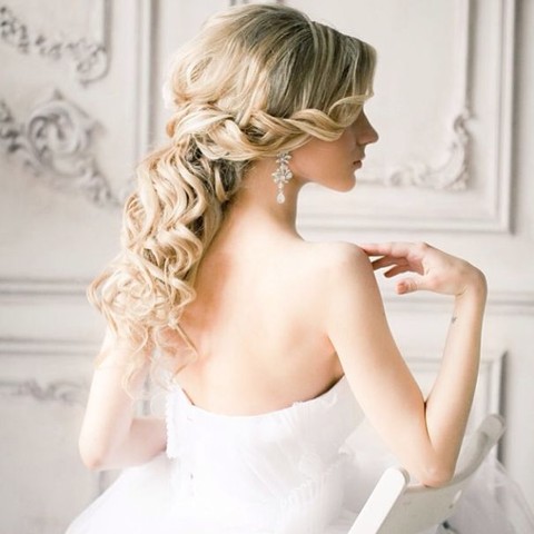 twisted half updo with waves and bangs and volume on top looks trendy and fashionable