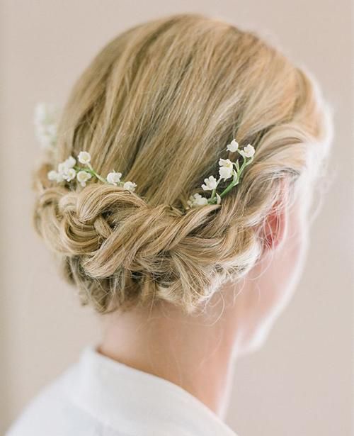 a curled updo with a fresh flower accent