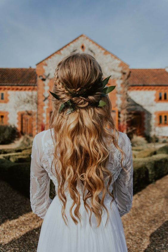 a relaxed boho wedding half updo with a large loose braid and waves down is a beautiful and easy to make idea