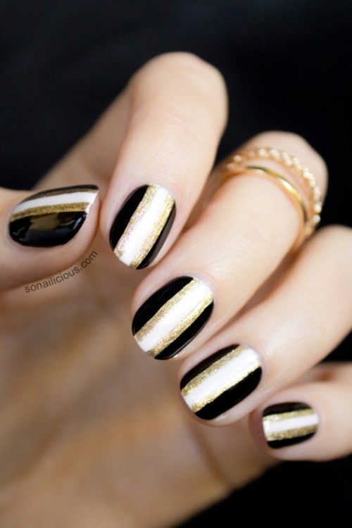burgundy nails with gold glitter accents and a bold chevron nail for a more outstanding look